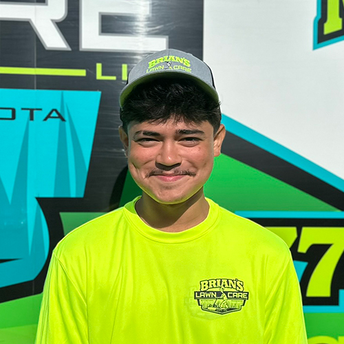 Photo of Brian's Lawn Care employee next to service truck.
