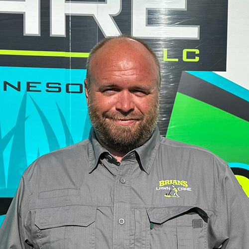 Photo of Brian's Lawn Care owner next to service truck.