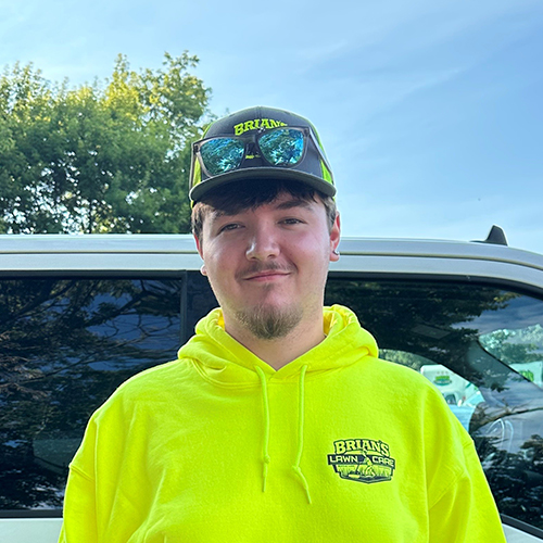 Photo of Brian's Lawn Care employee next to service truck.