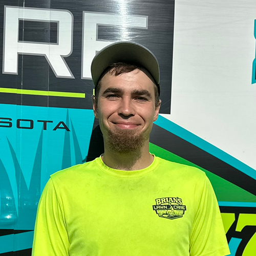 Photo of Brian's Lawn Care employee next to service truck.