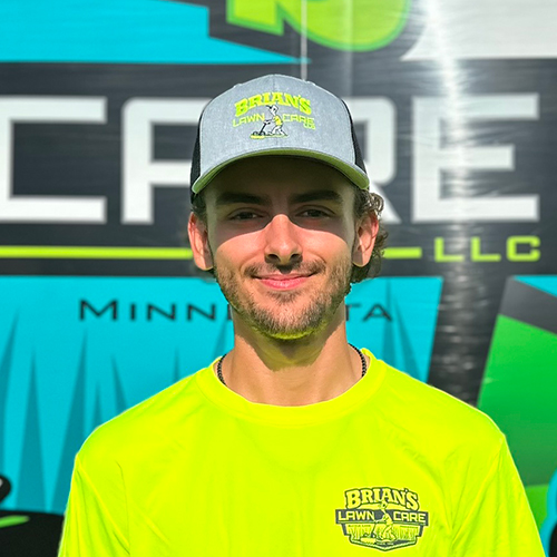 Photo of Brian's Lawn Care employee next to service truck.