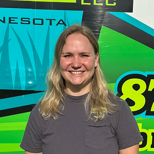 Photo of Brian's Lawn Care employee next to service truck.