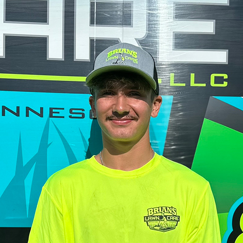 Photo of Brian's Lawn Care employee next to service truck.