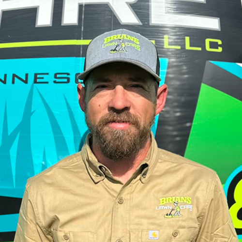 Photo of Brian's Lawn Care employee next to service truck.